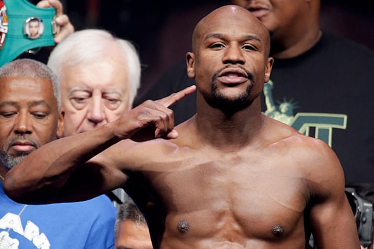 Floyd Mayweather Jr. poses on the scales during the official weigh-in at the MGM Grand Hotel in Las Vegas, Friday, May 2, 2014. Mayweather is to face Marcos Maidana in a welterweight title fight on Saturday. (Chris Carlson/AP)