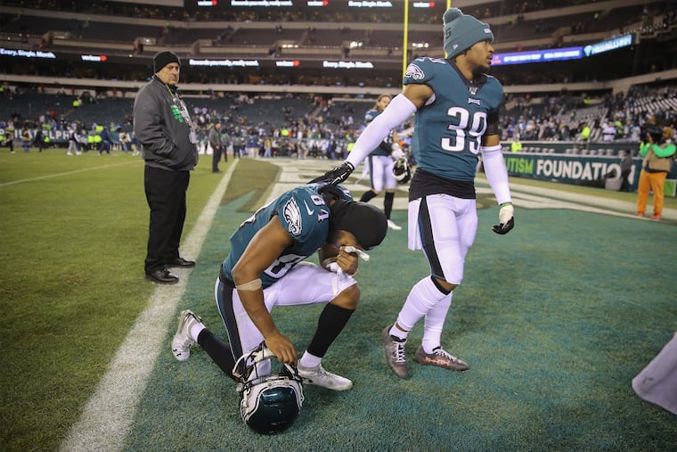 Eagles wide receiver Greg Ward, kneeling, is comforted by Eagles cornerback Craig James as they absorb the loss to the Seahawks.