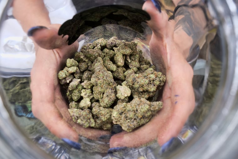 FILE - In this April 21, 2018, file photo a bud tender displays a jar of cannabis at the High Times 420 SoCal Cannabis Cup in San Bernardino, Calif. Businesses inside and outside the multibillion-dollar cannabis industry are using April 20, or “420,” to roll out marketing and social media messaging aimed at connecting with marijuana enthusiasts. (AP Photo/Richard Vogel, File)