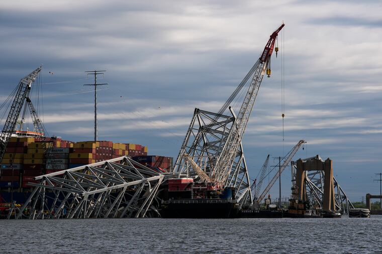 The collapsed Francis Scott Key Bridge lies on top of the container ship Dali, Thursday, April 25, 2024, in Baltimore.