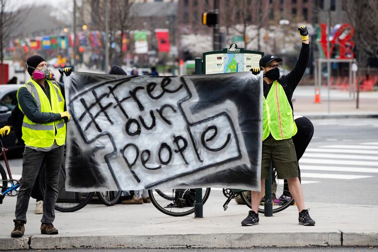 Protesters call for officials to release people from jails, prisons, and immigration detention centers in response to the coronavirus, as they demonstrate outside City Hall on March 30.