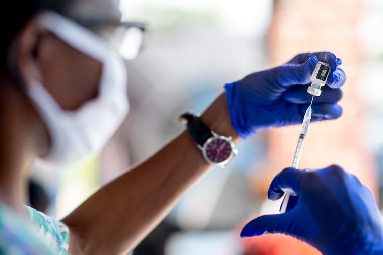 A nurse prepares a doze of the Pfizer COVID-19 vaccine during a vaccination drive. (Emily Kask/The New York Times)