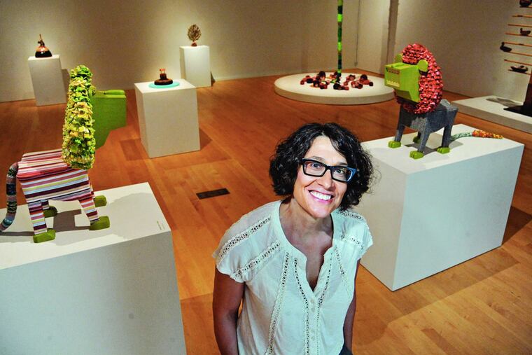 Philadelphia artist Shelley Spector stands amid her art exhibit “Keep the Home Fires Burning” at the Philadelphia Museum of Art’s Perelman Building. ( CLEM MURRAY / Staff Photographer )