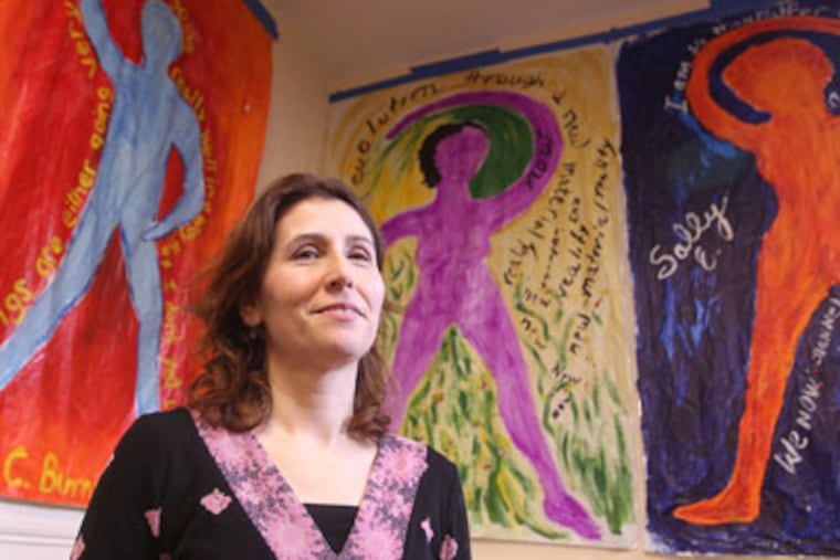 Artist Elise Luce Kraemer in front of her paintings featuring the words of protesters. She plans to expand her work to 99 panels. (Charles Fox / Staff Photographer)