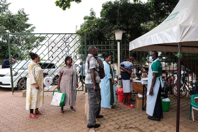 People wait to have their temperature taken in front of Kibuli Muslim Hospital in Kampala, Uganda, Saturday, May 16, 2026.