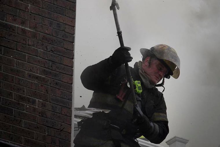 Philadelphia Firefighters at scene of an apartment house fire at corner of S. 11th St. at Fitzwater on Friday morning. Fire spread into the roof at this location and firefighters are attacking from all sides. ( ALEJANDRO A. ALVAREZ / STAFF PHOTOGRAPHER )