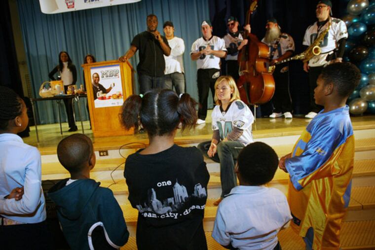 EAGLES Omar Gathers (holding mike) and Chris Gocong (behind him) meet with pupils at Grover Cleveland Elementary School in North Philly yesterday, as part of "My Breakfast Promise," a program to promote the importance of students' eating a healthy breakfast.