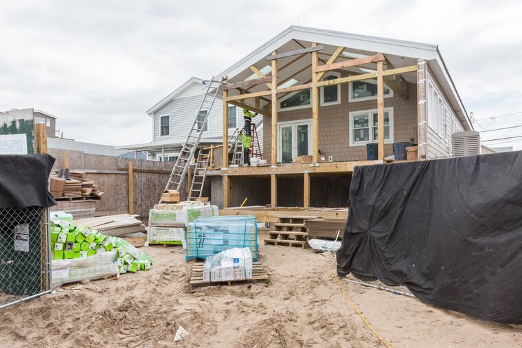 Workers install a gutter during construction of a home designed to withstand extreme weather in the Breezy Point neighborhood of the Queens borough of New York.