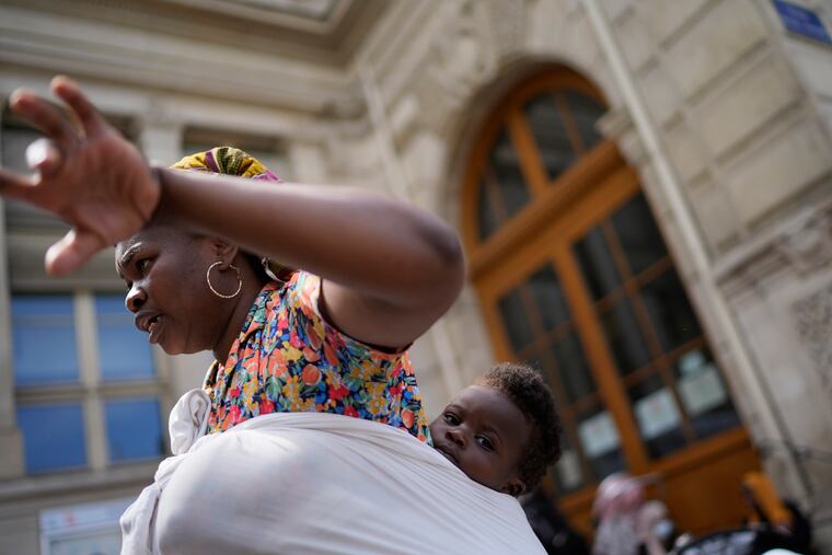 Natasha Louise Gbetie, from Burkina Faso, and her son Richard Emmanuel, attend a protest at the 2024 Summer Olympics on Thursday in Paris, France.