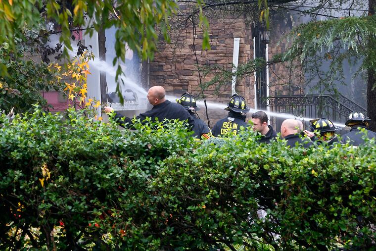 Woodbridge firefighters work to extinguish the scene of a plane crash at a home in Woodbridge, N.J., Tuesday, Oct. 29, 2019. (AP Photo/Noah K. Murray)