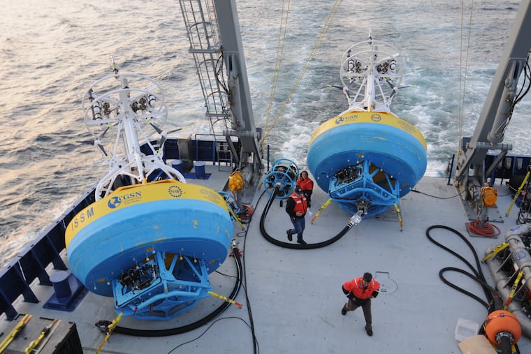 In this 2021 image provided by Woods Hole Oceanographic Institution, workers walk near buoys used to gather data at Pioneer New England shelf off the coast of Martha’s Vineyard, Mass. Scientists are scheduled to begin pulling up research buoys off the Oregon coast n Tuesday.