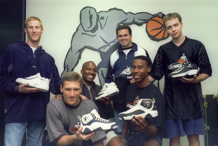The six partners in the basketball shoe & clothing business AND1 pose with some of their products in front of the company logo. From left to right: Jay Coen Gilbert, Seth Berger, Ray Moseley, Bart Houlahan, Guy Harkless and Tom Austin.