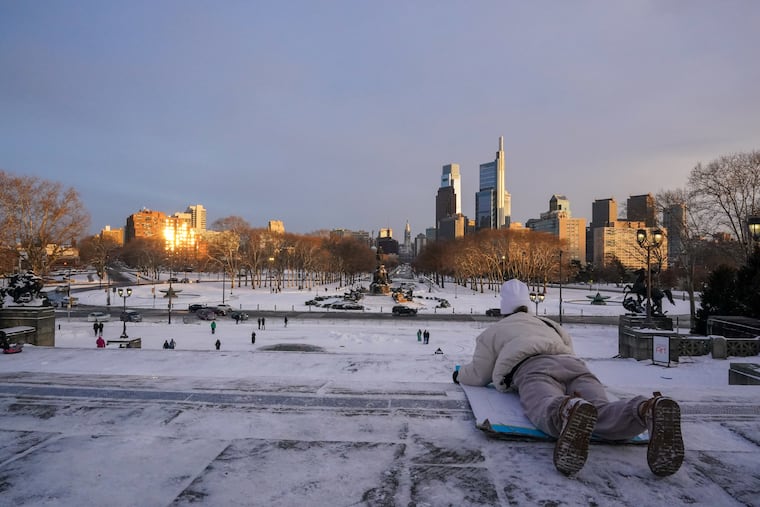 Brooke Piazza prepares to takeoff sledding on a piece of cardboard at the Philadelphia Art Museum in Philadelphia, Pa., on January 29, 2022.