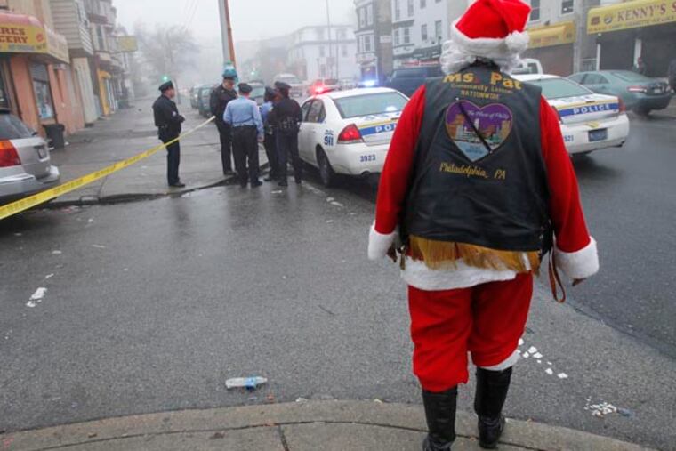 Philadelphia police investigate a shooting along Wayne Ave at Clapier in the Germantown section of the city on Monday morning December 10, 2012. Shown in foreground is Pat Redmond, aka Mrs. Pat, Heart of Philly community liaison at the crime scene. ( ALEJANDRO A. ALVAREZ / STAFF PHOTOGRAPHER )