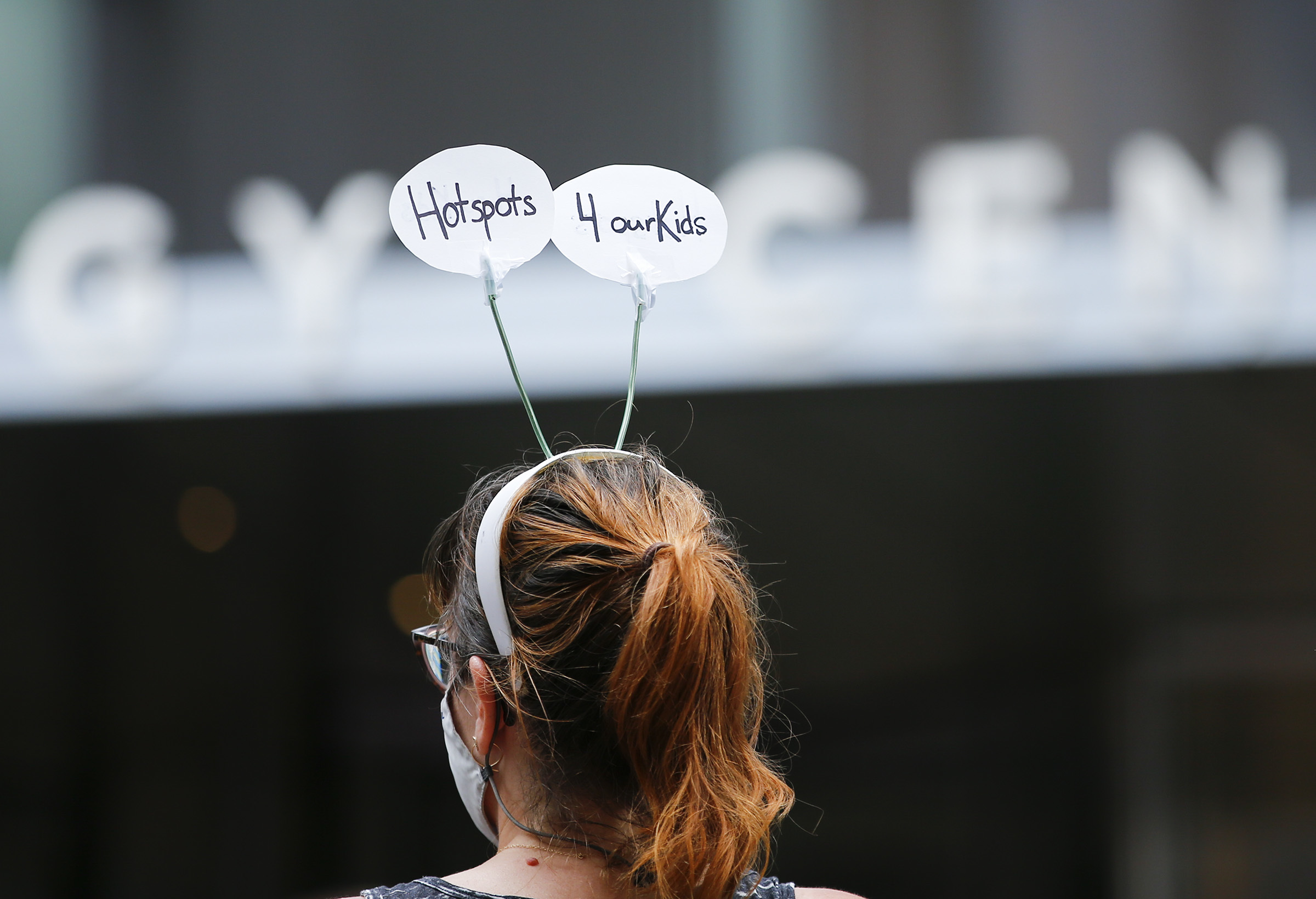 Anna Reed wears her "Hotspots 4 Our Kids" antenna during a protest at the Comcast Technology Center in Center City on Monday, August 3, 2020. Internet access for students has become more crucial as schooling goes remote during the coronavirus pandemic, writes Philadelphian and Syrian refugee Nasr Sadar.