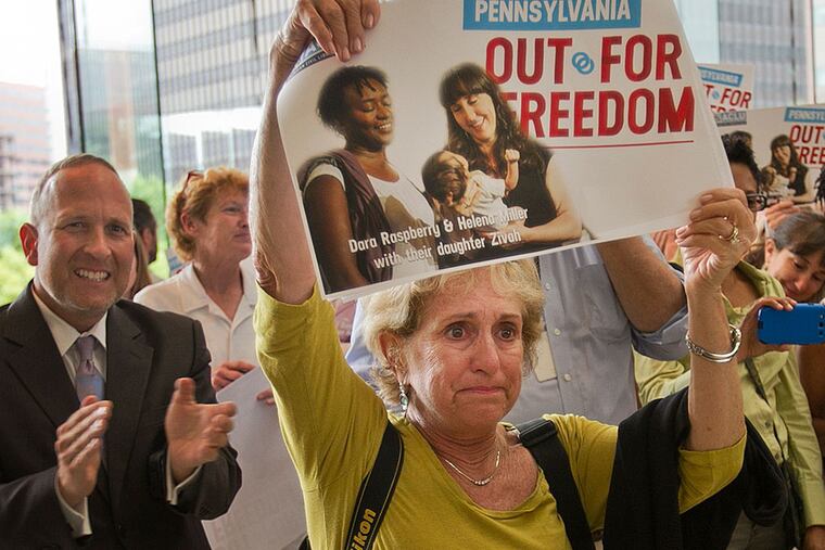 Julie Miller, mother of Helena Miller a gay woman shows her support for gay rights. The poster she is holding has an image of her daughter and partner Dr. Dara Raspberry and their daughter Zivah Raspberry. Pennsylvania Attorney General Kathleen Kane at Constitution Center at 6th and Arch St. in Philadelphia on Thursday, July 11, 2013. She spoke on the constitutionality of Pennsylvania's ban on same sex marriage. ( ALEJANDRO A. ALVAREZ / STAFF PHOTOGRAPHER )