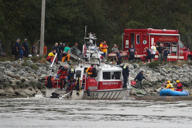 Emergency personnel, including divers, work on the Chesapeake & Delaware Canal where a vehicle plunged into the water from South Canal Road, west of St. Georges, Del., Sunday, Oct. 6, 2019. (William Bretzger/The News Journal via AP)