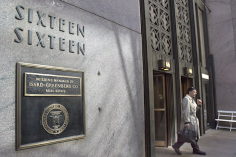 An unidentified pedestrian leaves the building at 1616 Walnut Street on Monday. (David Maialetti / Staff Photographer)