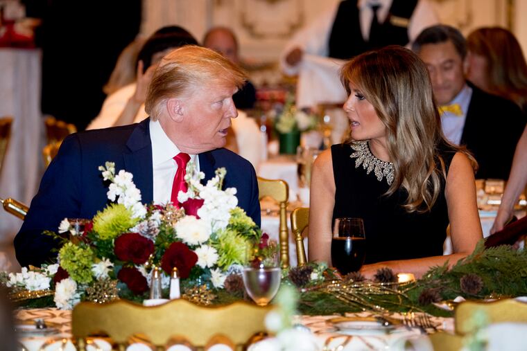 President Donald Trump and first lady Melania Trump talk at Mar-a-lago while there for Christmas Eve dinner in Palm Beach, Fla., Tuesday.
