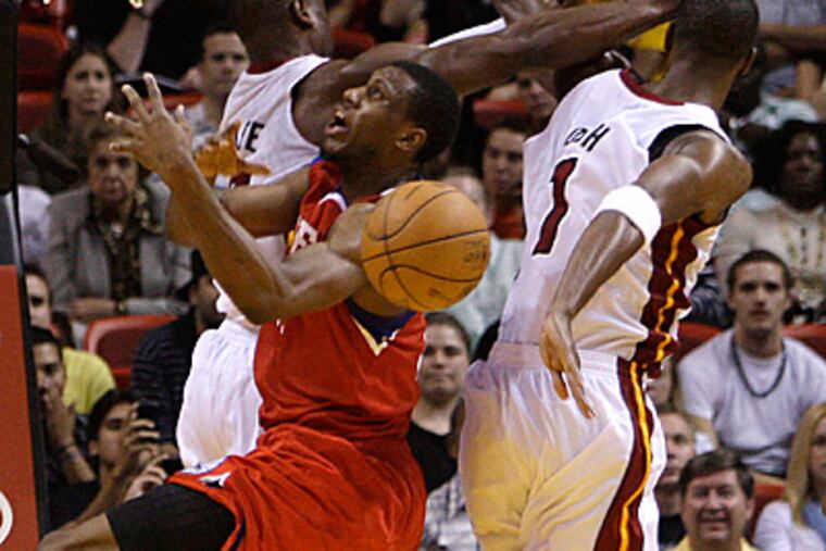 Thaddeus Young is fouled by Miami Heat's Dwyane Wade, left, and Chris Bosh. The Heat beat the 76ers, 99-90. (AP Photo/Lynne Sladky)