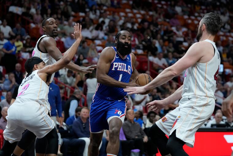 Sixers guard James Harden (1) drives to the basket between Heat defenders on Wednesday. Harden finished with 23 points, seven rebounds, and five assists.