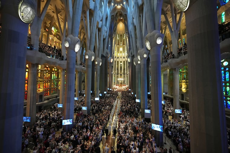Pope Leo XIV (bottom) walks in procession to celebrate Mass on Wednesday in the Basilica of the Sagrada Familia in Barcelona, Spain.