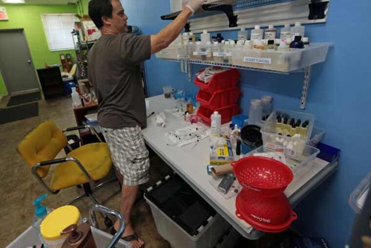 Owner Dean Hutton mixes a tank of juice for a customer on Sunday, Sept. 28, 2014, in the back room at MOvape Electronic Cigarette Store in St. Louis. (Laurie Skrivan/St. Louis Post-Dispatch/MCT)