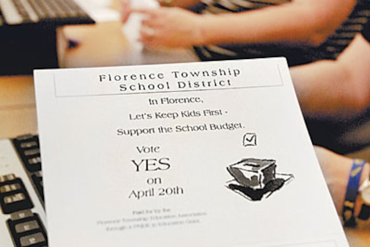 Florence High teachers stuff envelopes with letters urging support for the district budget. (ELIZABETH ROBERTSON/Staff Photographer)