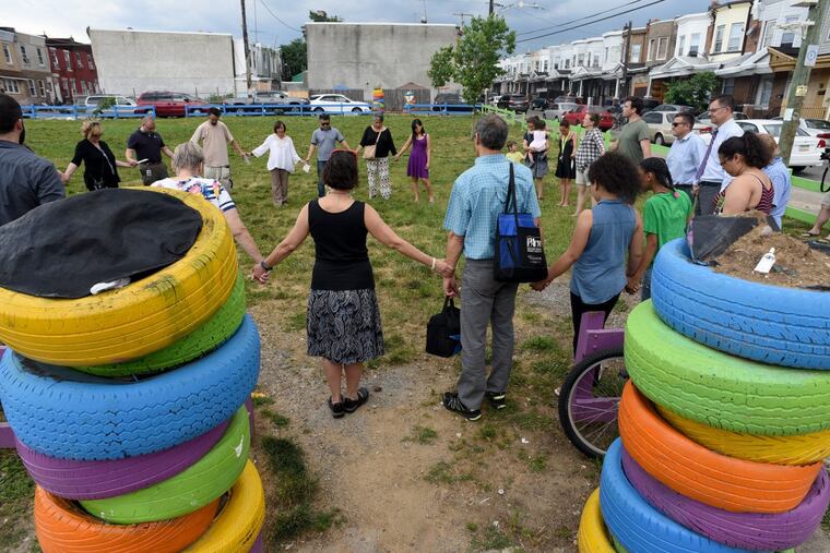 Neighbors hold hands and pray in Phoenix Park June 21, 2017 to observe the anniversary of a massive warehouse fire on the site ten years ago that destroyed homes and lives in Kensington. The neighborhood has s-l-o-w-l-y recovered but much still needs to be done. TOM GRALISH / Staff Photographer