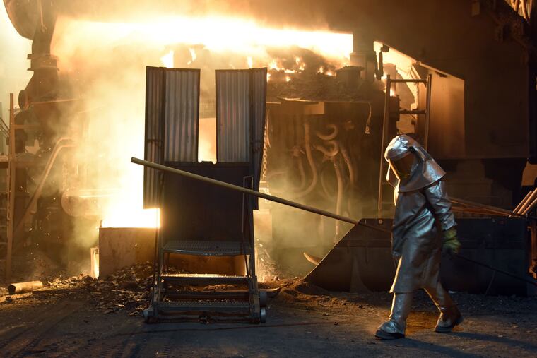 A steelworker checks the temperature of molten metal in furnace at the TMK Ipsco Koppel plant in Koppel, Pa., in 2018.