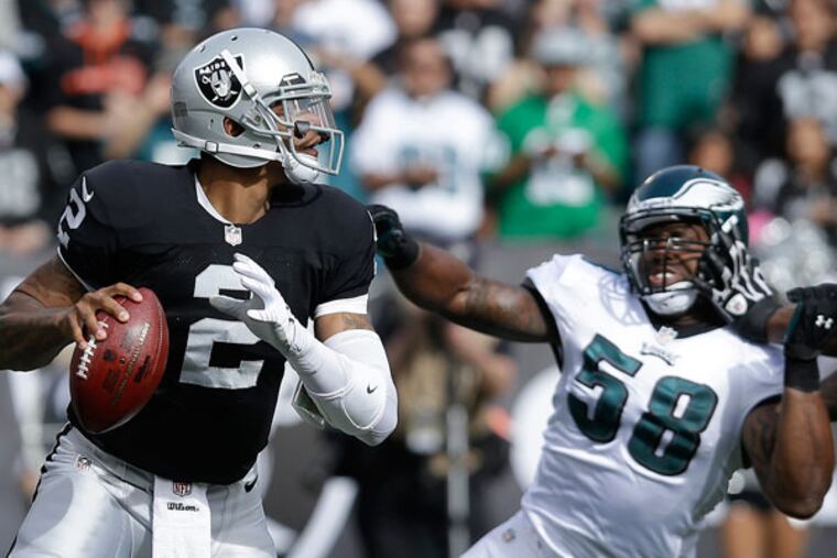 Raiders quarterback Terrelle Pryor (2) drops back to pass as Philadelphia Eagles outside linebacker Trent Cole (58) applies pressure during the first quarter of an NFL football game in Oakland, Calif., Sunday, Nov. 3, 2013. (Jeff Chiu/AP)