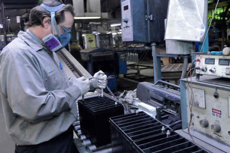 Timothy Holler fastens elements into battery cases at the firm's plant in New Castle, Pa.
