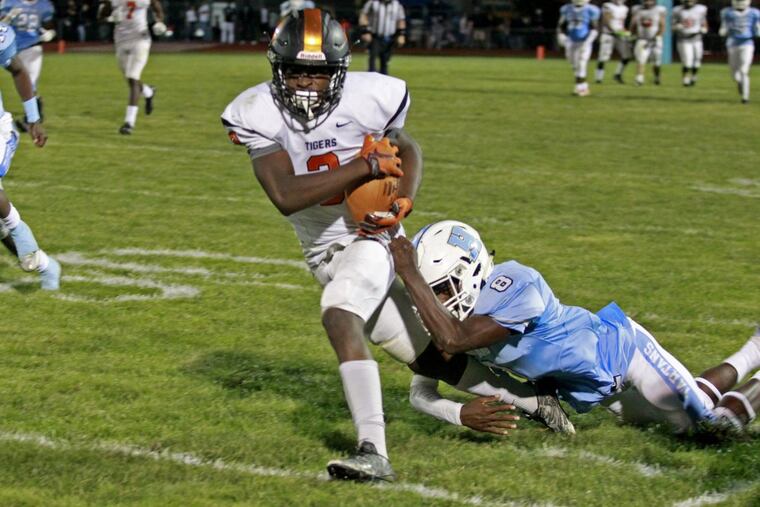 Woodrow Wilson’s Hydir Moore (left) runs the ball earlier this season.