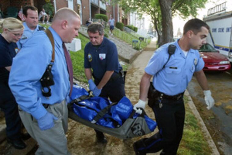 Police remove the body of Michael Lopuskanski from his apartment in Torresdale yesterday after he was discovered with multiple stab wounds and lying face-up in his living room.