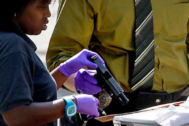Investigators collect a gun found at the scene of a shooting in the parking lot of the Victory for the World Baptist Church that occurred after a funeral wrapped up Thursday, June 7, 2012, in Stone Mountain, Ga. Police say two people were killed and two others injured. (AP Photo/John Bazemore)