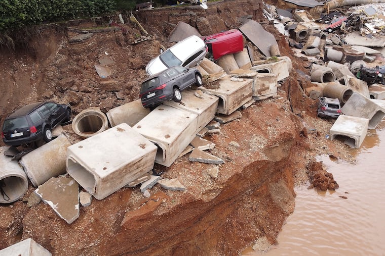 Debris of the sewage system and damaged cars are pictured in the Blessem district of Erftstadt, Germany, on Friday.