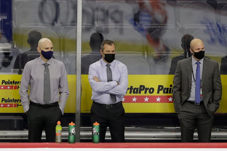 Flyers head coach Alain Vigneault and his staff watch warmups before Sunday's scrimmage at the Wells Fargo Center. From left to right: Ian Laperriere, Vigneault, Mike Yeo and Michel Therrien.