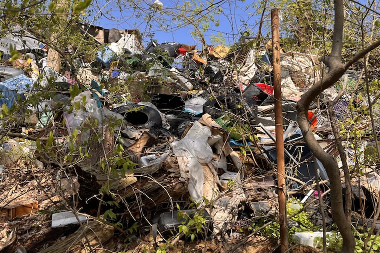 A view of a small portion of an illegal dump that spans a block off Pennway Street in Northeast Philadelphia and spills down a ravine as viewed April 10, 2026.