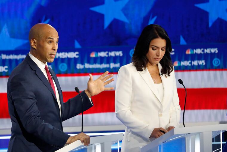 Democratic presidential candidate Sen. Cory Booker, D-N.J., speaks as Rep. Tulsi Gabbard, D-Hawaii, listens during a Democratic presidential primary debate, Wednesday, Nov. 20, 2019, in Atlanta.