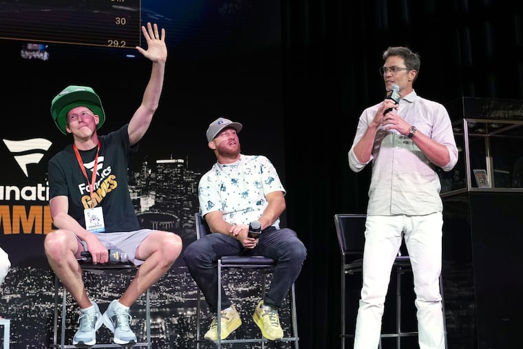 Pennsylvania high school teacher Matt Dennish (left) waves to the crows moments before Tom Brady (far, right) offered to buy the LeBron James rookie card Dennish won by placing third in last year's Fanatics Games.