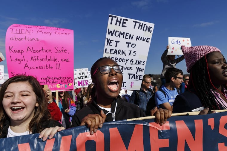Demonstrators shout as they hold a banner during the Chattanooga Women’s March on Saturday, Jan. 20, 2018, in Chattanooga.
