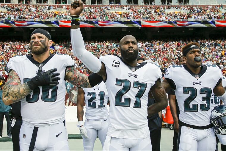 Eagles strong safety Malcolm Jenkins raises his fist with teammate defensive end Chris Long (left) and free safety Rodney McLeod during the National Anthem before the played the Washington Redskins on Sept. 10, 2017 in Landover, Md. Y