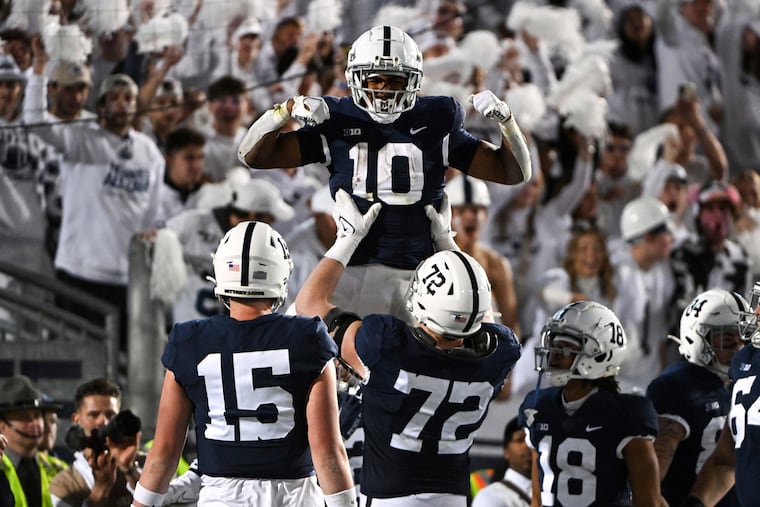 Penn State running back Nicholas Singleton is lifted by offensive lineman Bryce Effner after Singleton's touchdown against Minnesota on Oct. 22, 2022.