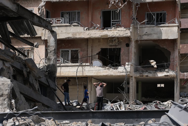 Residents on Friday inspect damage to buildings hit by Israeli airstrikes in Jibchit, southern Lebanon.