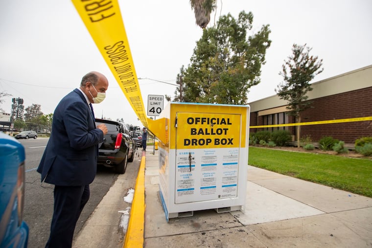 Baldwin Park Mayor Manuel Lozano views the fire damage to the official ballot drop box where ballots were set on fire outside the Baldwin Park Library this week.