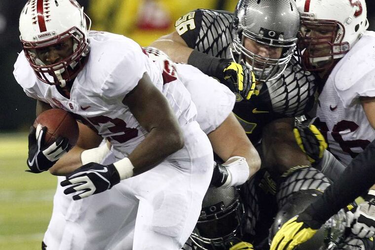 Stanford's Stepfan Taylor breaks away from Oregon defenders during the first half. The second-ranked Ducks led the No. 13 Cardinal, 14-7, in the fourth quarter of Saturday's game, which ended too late for this edition. DON RYAN / AP