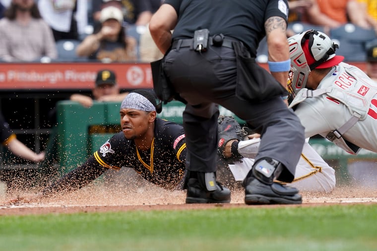 The Pirates' Ke'Bryan Hayes scores a second-inning run as Phillies catcher Rafael Marchan applies the late tag.