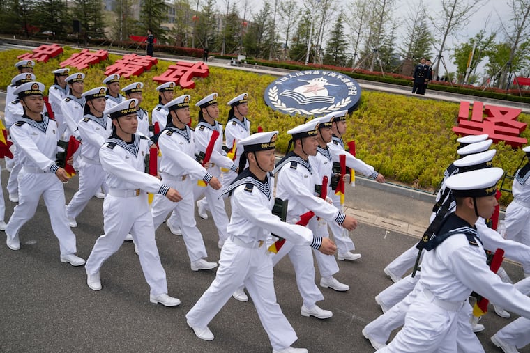 FILE - Sailors march past the insignia for the People's Liberation Army (PLA)'s naval submarine academy during a tour arranged for foreign journalists a day before the opening of the West Pacific Naval Symposium in Qingdao in eastern China's Shandong province, Sunday, April 21, 2024.