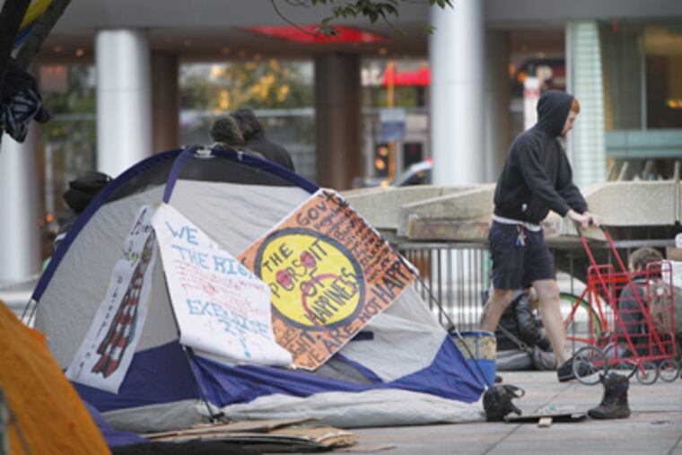 Protesters begin to wake up after sleeping overnight at Dilworth Plaza beside Philadelphia City Hall on Friday morning. (Alejandro A. Alvarez / Staff Photographer)