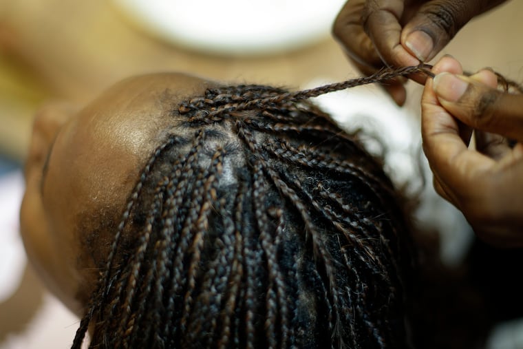 Shelly Smith braids hair at her salon, Braid Heaven, in Kansas City, Kan.